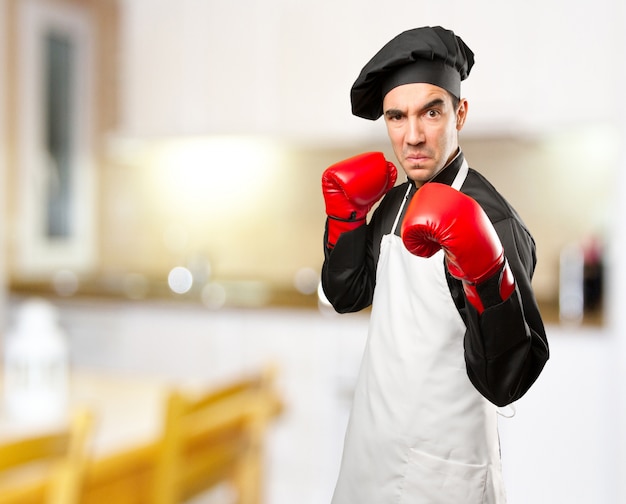 Cozinheiro irritado usando luvas de boxe