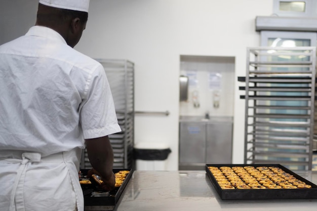 Foto cozinheiro masculino preparando tortas de ovos tradicionais portuguesas em pastelaria pastel de nata pastel de belém