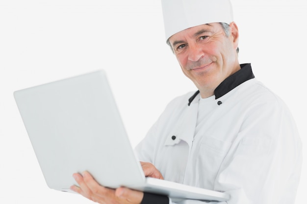 Cozinheiro masculino usando laptop sorrindo