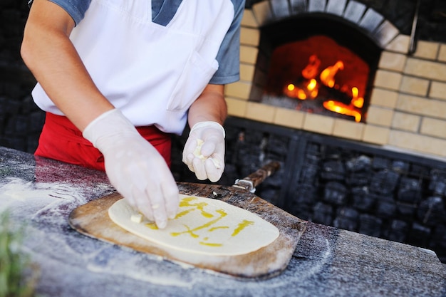 Cozinheiro ou padeiro prepara focaccia - pão italiano