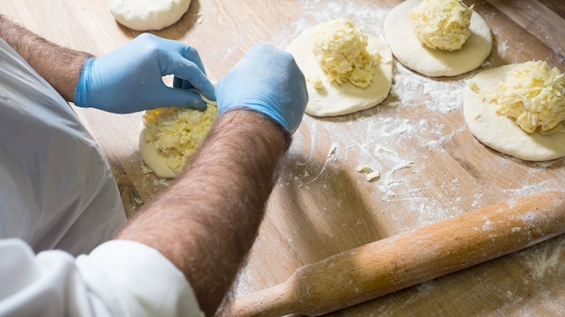 Cozinheiro profissional fazendo khachapuri com queijo. Cozinha tradicional georgiana