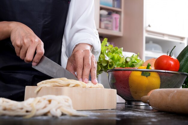 Cozinheiro que faz massa fresca de macarrão