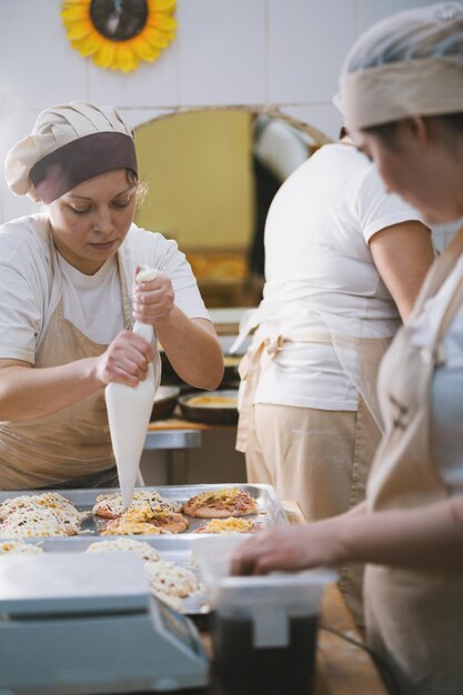 Cozinheiros cozinham minipizzas na confeitaria, close-up