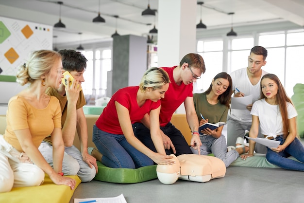 CPR-Kurs mit jungen Ausbildern, die Hilfe bei der Ersten Hilfe demonstrieren