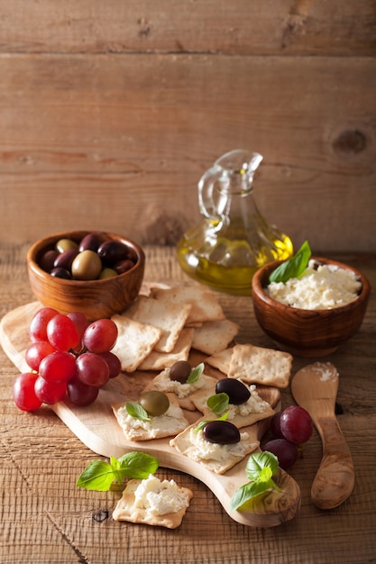 Cracker mit Weichkäse-Oliven-Trauben. gesunde Vorspeise