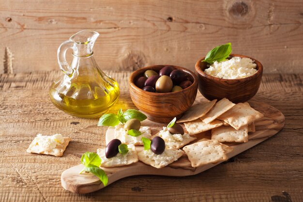Cracker mit Weichkäse und Oliven. gesunde Vorspeise