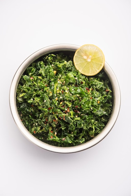 Crackling Spinach ou Crispy Palak é uma entrada indiana, servida em uma tigela ou prato com uma rodela de limão