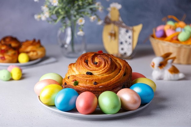 Craffin con pasas y frutas confitadas Pan de Pascua tradicional Kulich y huevos pintados sobre un fondo gris Fiestas de Pascua En primer plano enfoque selectivo