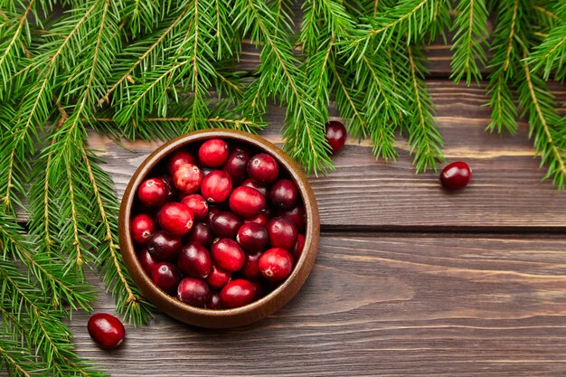 Cranberries frische Beeren in der Holzschale auf Tisch mit Christbaumzweigen