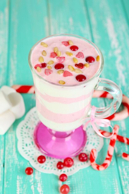 Cranberry-Milchdessert im Glas auf farbigem hölzernem Hintergrund