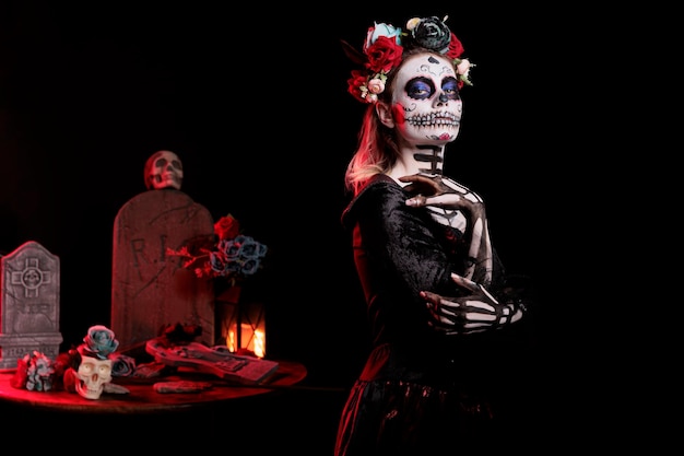 El cráneo aterrador se maquilla en una mujer glamorosa para celebrar la tradición mexicana dios de los muertos, posando en la celebración navideña. Dama de la muerte con traje de la cavalera catrina y body art.