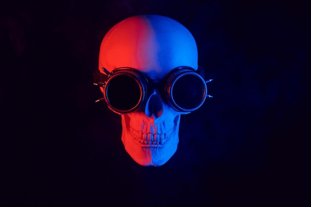 Cráneo humano en gafas steampunk con luz de neón roja y azul
