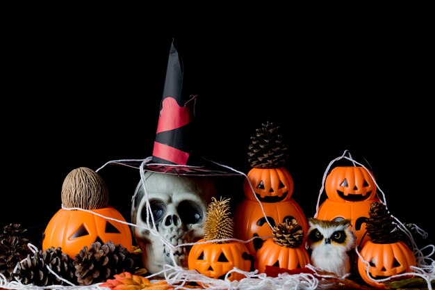 Cráneo humano de Halloween, calabazas de Halloween en una vieja mesa de madera delante de un fondo negro con espacio libre para texto. Conceptos de Halloween. Feliz día de Halloween.