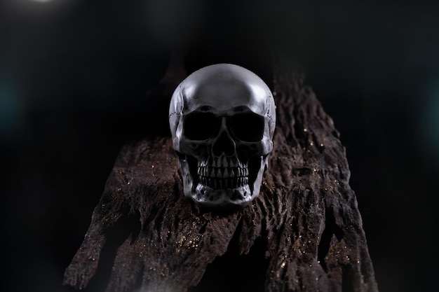 Cráneo humano de Halloween en una vieja mesa de madera sobre fondo negro Forma de hueso del cráneo para la cabeza de la muerte en el festival de halloween que muestra horror miedo al diente malvado y miedo con espacio de copia de humo de niebla
