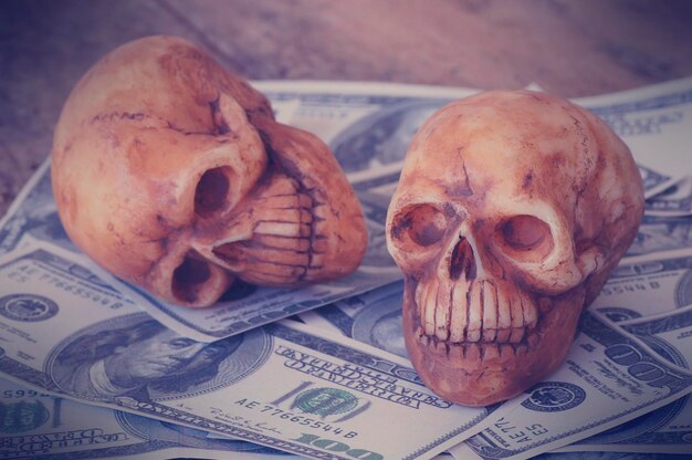crânio em notas e moedas conceito de dinheiro no trabalho para o dinheiro e morte por causa do dinheiro
