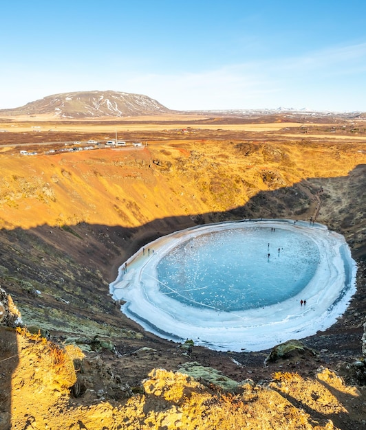 El cráter Kerid, un enorme cráter volcánico tranquilo en la temporada de invierno, se convierte en un lago de hielo duro en Islandia