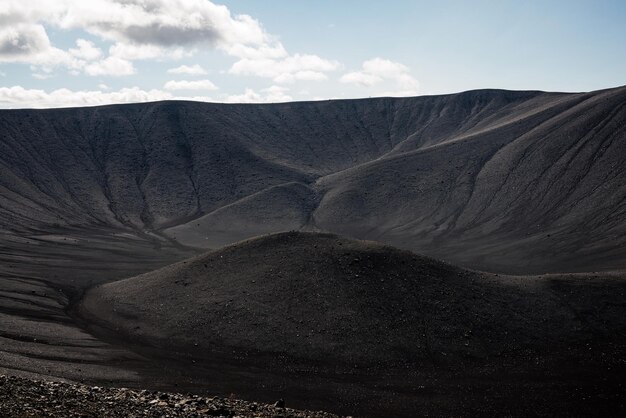 Cráter del volcán con arena negra y paisaje escénico en el fondo