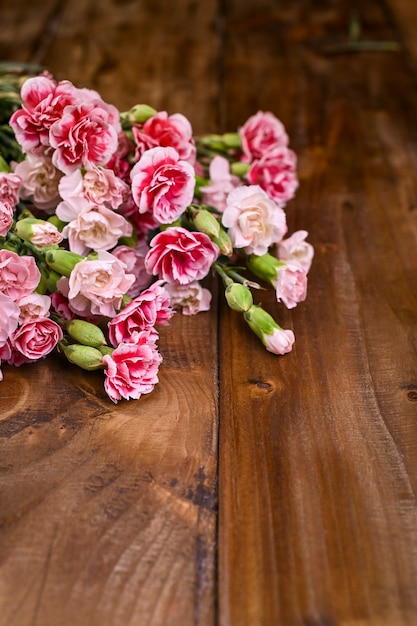 Cravo com pétalas de rosa e brancas em uma mesa de madeira