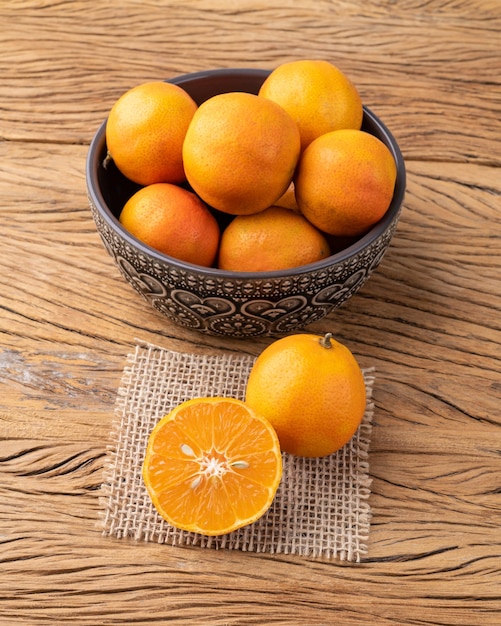 Foto cravo o limones rosas en un bol sobre una mesa de madera