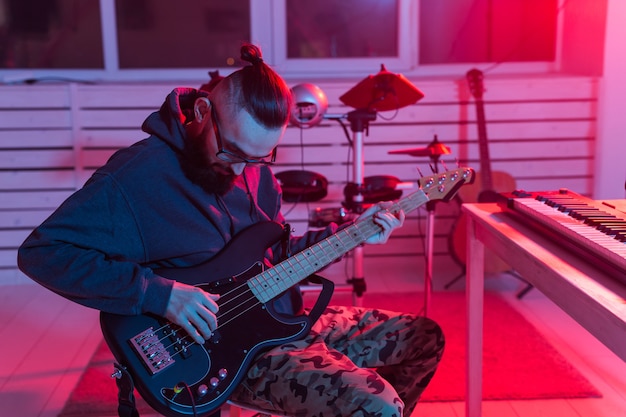 Foto crea música y un concepto de estudio de grabación: guitarrista barbudo gracioso grabando guitarra eléctrica