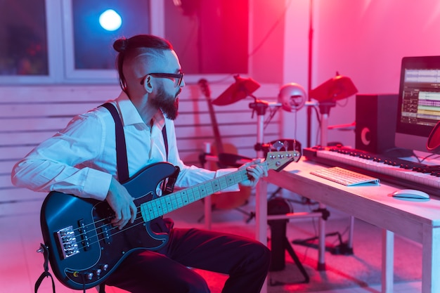 Crea música y un concepto de estudio de grabación: guitarrista de hombre barbudo grabando una pista de guitarra eléctrica
