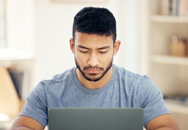 Creación de redes en línea Foto de un joven hombre de negocios que usa una computadora portátil en una oficina en el trabajo