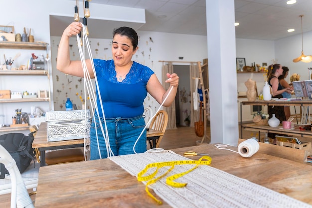 Creaciones de macramé hechas a mano hábil artesana en su estudio textil