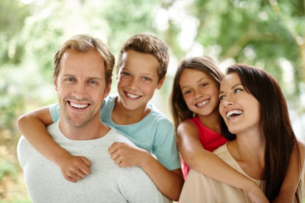 Creando recuerdos felices juntos Retrato de una familia feliz de cuatro personas pasando tiempo juntos al aire libre