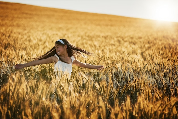 Creando recuerdos para toda la vida Foto de una linda niña dando vueltas en un campo de maíz