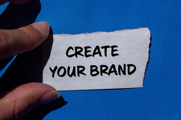 Crear su mensaje de marca escrito en papel rasgado con fondo azul Conceptual crear su símbolo de marca Copiar espacio