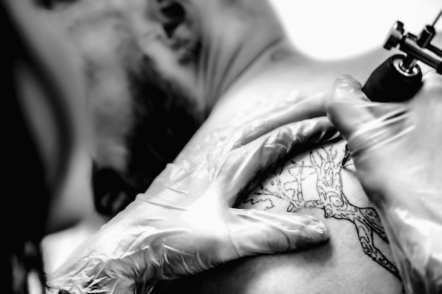 Crear un tatuaje en la espalda de un hombre en un estudio