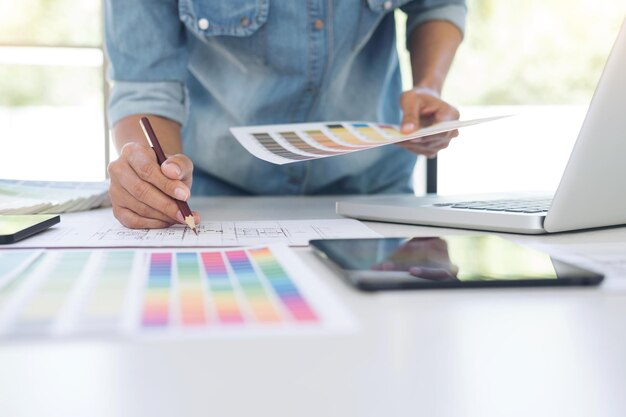 Creatividad diseñador gráfico trabajando con gráficos tableta portátil y teléfono inteligente tabla de colores en el lugar de trabajo en escritorio de madera ideas de color concepto de estilo