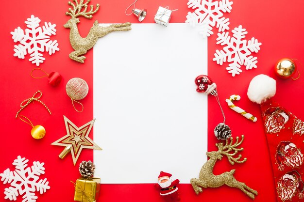 Creativo plano pone de caja de regalo y adornos con papel en blanco para el texto sobre fondo de color rojo, Navidad y feliz año nuevo concepto