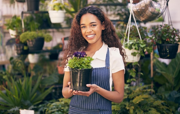 Crecer del verde Captura de una florista sosteniendo una de sus hermosas flores en maceta