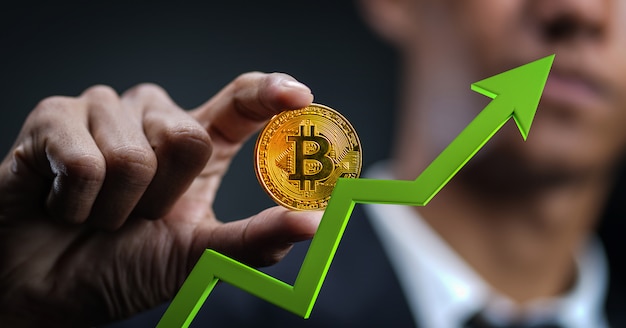 Crecimiento de Bitcoin. Empresario sosteniendo Bitcoin con flecha verde 3D hacia arriba