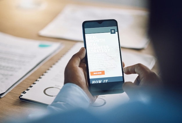 Crecimiento y estrategia del teléfono con un hombre de negocios en un escritorio en su oficina para trabajar mientras planifica en línea Mano móvil e Internet con un empleado masculino que lee datos de información o investiga un primer plano