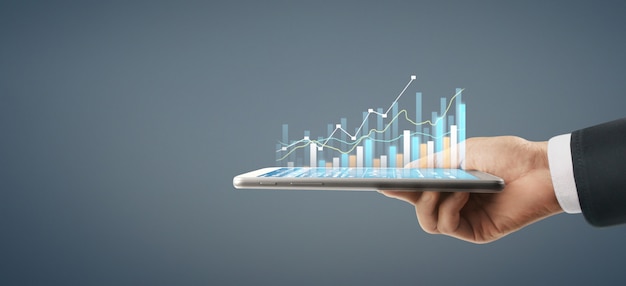 Crecimiento del gráfico del plan de negocios y aumento de los indicadores positivos del gráfico en su negocio, tableta en mano