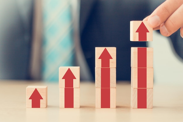 El crecimiento de los negocios va al éxito el proceso de progreso concepto hombre de negocios mano arreglando bloque de cubo de madera con crecer