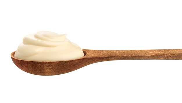 Crema agria en cuchara de madera aislada en blanco