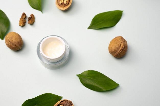 Crema amarilla hecha de ingredientes naturales con hojas verdes y nueces. El concepto de crear esencias a partir de ingredientes naturales.