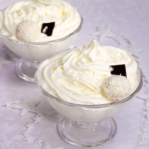 Crema batida decorada con galletas de chocolate y coco en un bol de vidrio