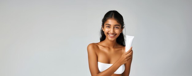 Crema de belleza chica india en vestido blanco con producto para el cuidado de la piel