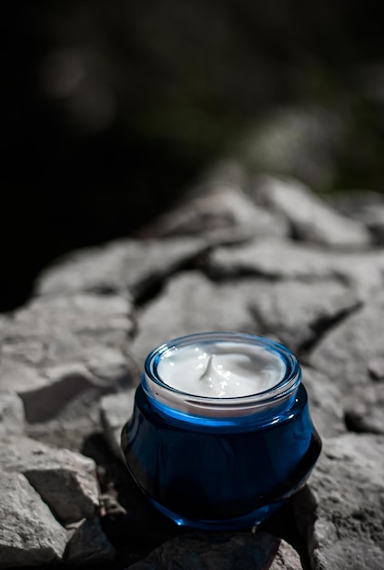 Crema de belleza hidratante para el cuidado de la piel y cosméticos de spa sobre fondo de piedra en verano al atardecer producto cosmético y cuidado de la piel