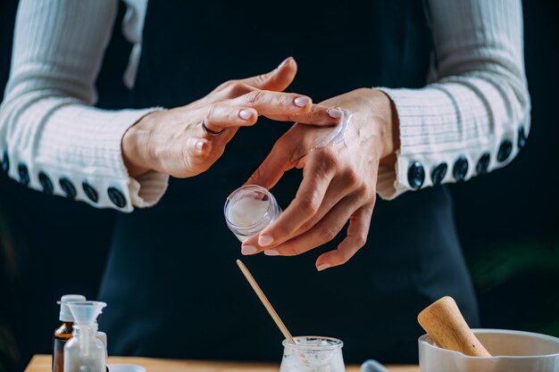 Crema de bricolaje en casa Mujer aplicando crema de manos casera en sus manos