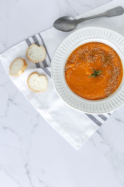 Crema de calabaza casera y saludable con pan desde arriba sobre mesa de mármol. Endecha plana