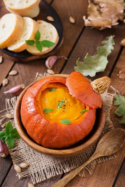 Crema de calabaza con pimientos y hierbas en una calabaza