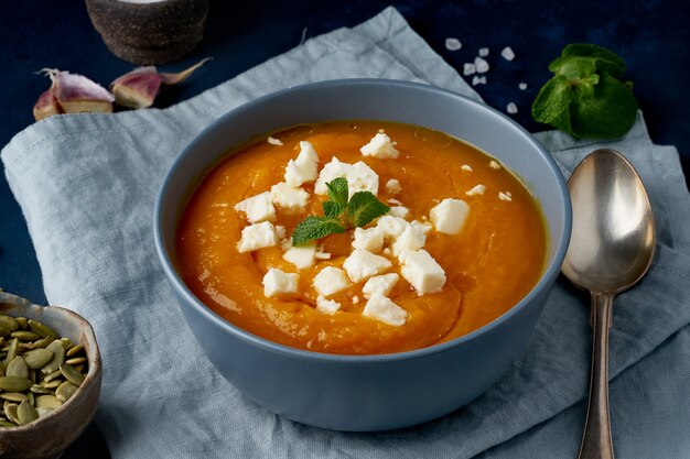 Crema de calabaza con queso feta, comida casera de otoño, azul oscuro