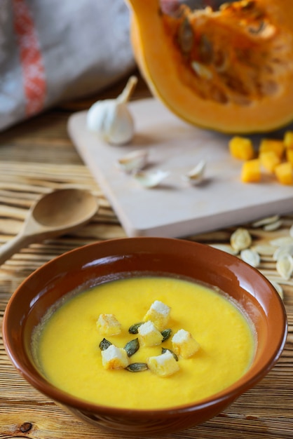 Crema de calabaza con semillas y picatostes en un tazón.