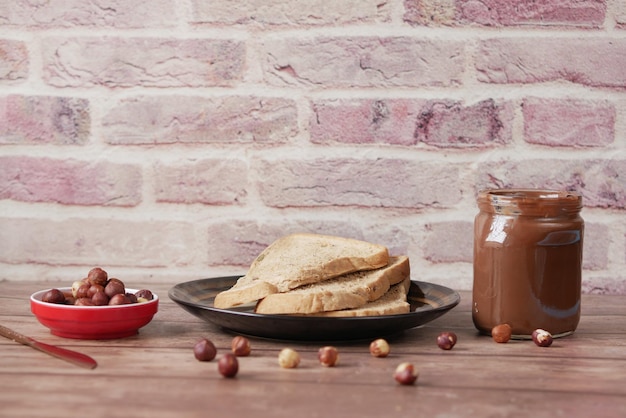 Crema de chocolate con avellanas en un recipiente sobre la mesa