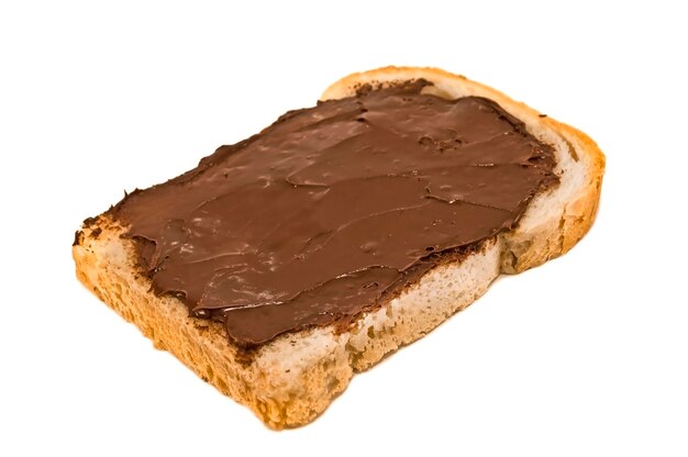 Crema de chocolate con avellanas en la tostada de pan sobre fondo blanco.